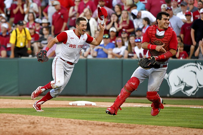 North Carolina State's Austin Murr (12) and Luca Tresh (24) celebrate after making the final out to beat Arkansas 3-2 at Fayetteville to advance to the College World Series on Sunday, June 13, 2021. (AP/Michael Woods)