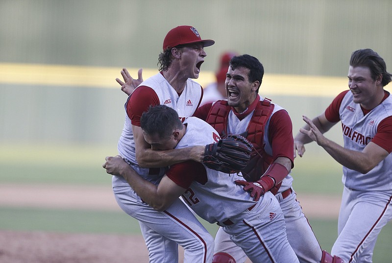 North Carolina State players celebrate, Sunday, June 13, 2021 following Arkansas' 3-2 loss to North Carolina State in Game 3 of the Fayetteville Super Regional at Baum-Walker Stadium in Fayetteville. Check out nwaonline.com/210614Daily/ for today's photo gallery. .(NWA Democrat-Gazette/Charlie Kaijo)