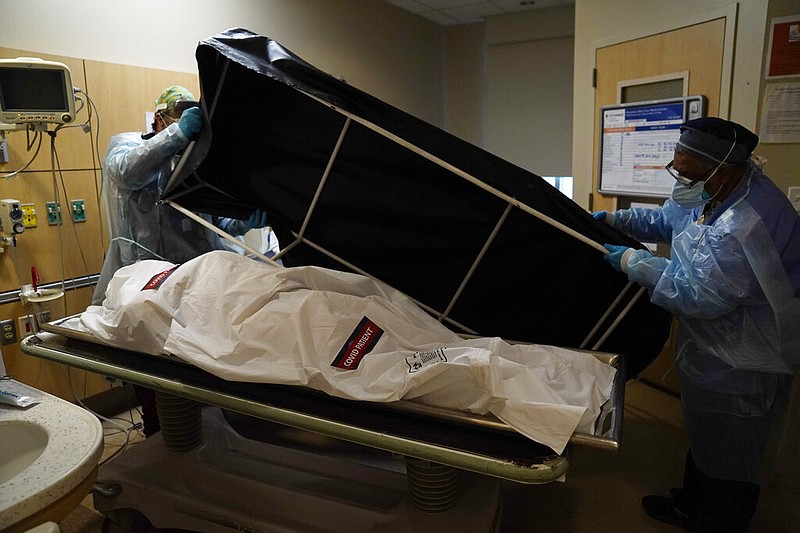 FILE - In this Jan. 9, 2021 file photo, transporters Miguel Lopez, right, Noe Meza prepare to move a body of a covid-19 victim to a morgue at Providence Holy Cross Medical Center in the Mission Hills section of Los Angeles. (AP/Jae C. Hong, File)