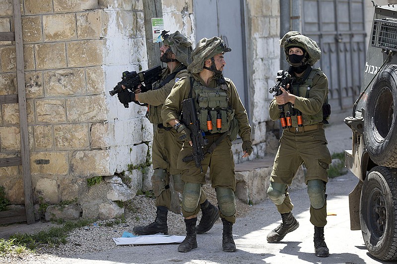 Israeli soldiers patrol in May 2020 after a soldier was killed by a rock thrown off a rooftop during a raid in the village of Yabad near the West Bank city of Jenin. Israeli activist groups say the practice of “arbitrary invasions” of private homes “effectively serves as a means to oppress and intimidate the Palestinian population and increase control over it.”
(AP/Majdi Mohammed)