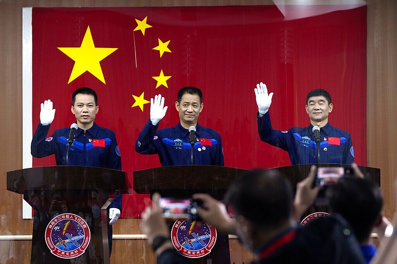 Chinese astronauts, from left, Tang Hongbo, Nie Haisheng, and Liu Boming wave at a press conference at the Jiuquan Satellite Launch Center ahead of the Shenzhou-12 launch from Jiuquan in northwestern China, Wednesday, June 16, 2021. China plans on Thursday to launch three astronauts onboard the Shenzhou-12 spaceship, who will be the first crew members to live on China's new orbiting space station Tianhe, or Heavenly Harmony from the Jiuquan Satellite Launch Center in northwest China. (AP Photo/Ng Han Guan)