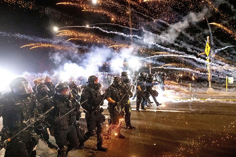 Police use chemical irritants and crowd control munitions to disperse protesters during a demonstration in Portland, Ore., in September. Officers on a rapid response team have resigned after one was charged with striking a protester last year.
(AP/Noah Berger)
