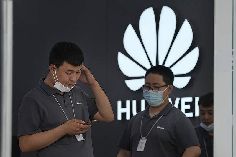 Huawei store workers wait for customers in Beijing in this fi le photo. The FCC has proposed a ban on products from Huawei Technologies Co.
(AP)