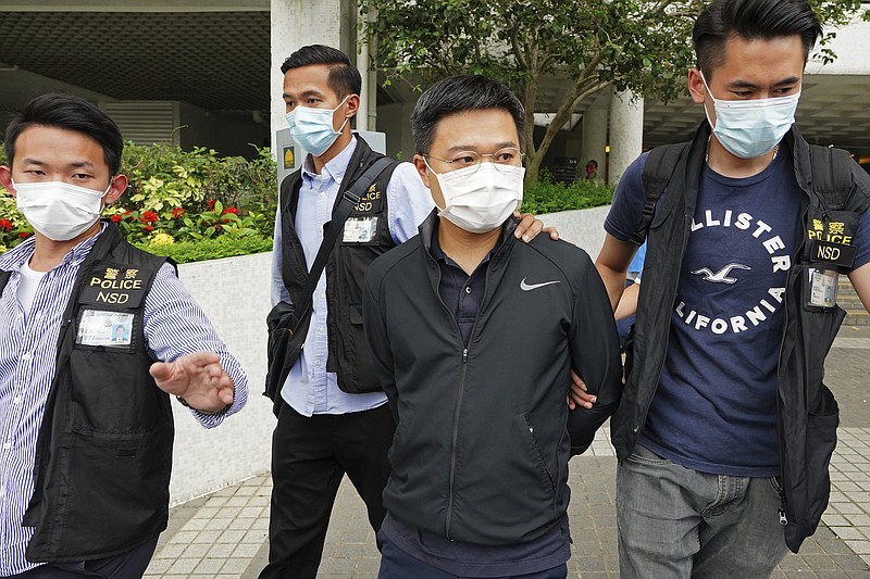 Ryan Law (third from left), Apple Daily’s chief editor, is escorted Thursday by police officers in Hong Kong after his arrest on suspicion of colluding with a foreign country, according to media reports.
(AP)