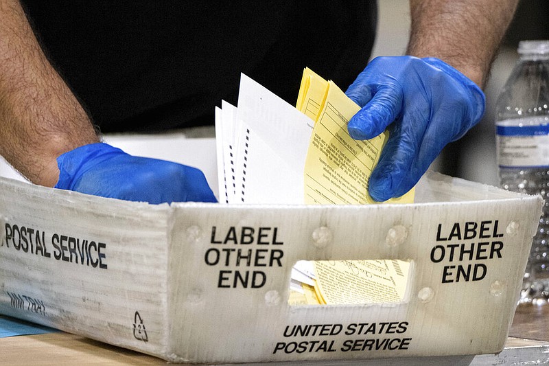 FILE - In this Jan. 5, 2021 file photo, Fulton County Georgia elections workers process absentee ballots for the Senate runoff election in Atlanta. Reports from an independent monitor who observed election operations in Georgia's most populous county during the 2020 election cycle detail tense encounters with party election monitors. (AP Photo/Ben Gray, File)