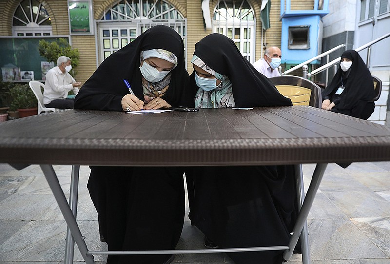 A voter fills out her ballot papers Friday at a polling station in Tehran during the Iranian presidential election.
(AP/Vahid Salemi)