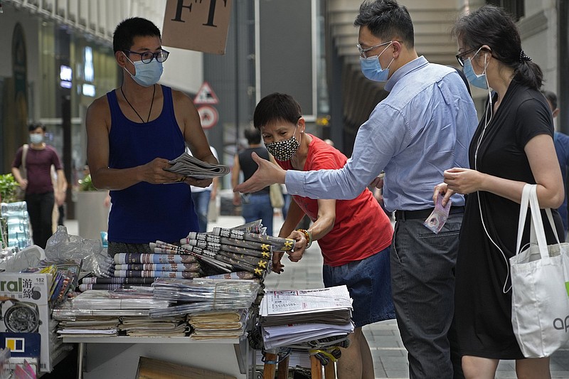 People line up Friday to buy copies of the Apple Daily at a downtown stand in Hong Kong in a show of support for the newspaper.
(AP/Vincent Yu)