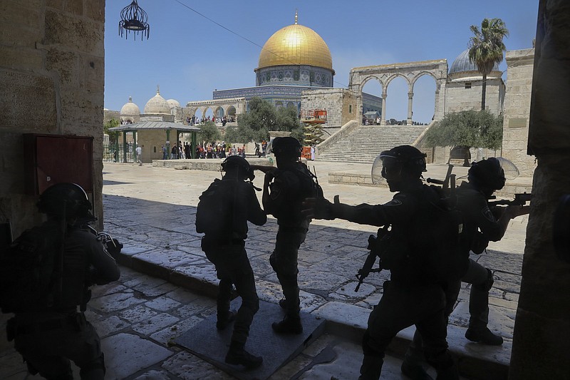 Israeli security forces take positions Friday during clashes with Palestinians in front of the Dome of the Rock Mosque at the Al Aqsa Mosque compound in Jerusalem’s Old City.
(AP/Mahmoud Illean)