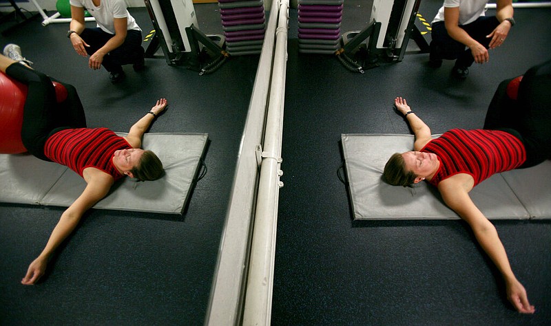 Amy Lottes works out at the YMCA with the help of her personal trainer, Gina Pona-Norton, in Kirkwood, Mo., in this Nov. 21, 2007, file photo. Lottes had lost weight four years earlier, and kept it off with the help of exercise and portion control. (AP/Whitney Curtis)