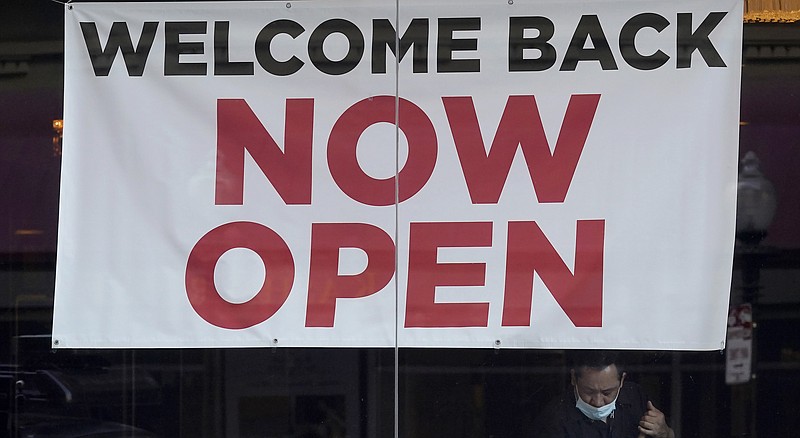 A sign reading "Welcome Back Now Open" is posted on the window of a restaurant as a man works inside in this March 4, 2021, file photo. Small businesses across the country are working to recover from the pandemic. (AP/Jeff Chiu)