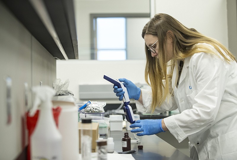 Carrie Sokol, a forensic toxicologist, runs a drug screening in the state Crime Laboratory's branch office in Lowell in this Jan. 24, 2020, file photo. (NWA Democrat-Gazette/Ben Goff)