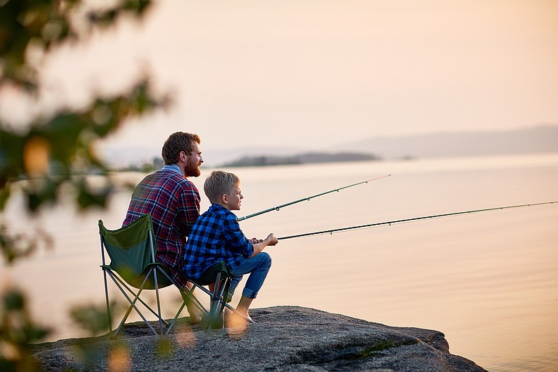 In this file photo, a child fishes with their dad. (iStock.com)