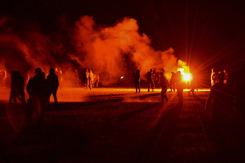 People stand in a field where partygoers were clashing with police officers Friday near Redon, France.
(AP)