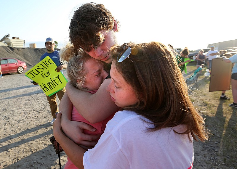Kaden Williams, 16, a friend of Hunter Brittain, hugs Brittain’s cousins Jazmine Brittain (left) and her sister, Jade (right), after a rally outside the Lonoke County sheriff’s office Wednesday in Lonoke. Hunter Brittain was shot by a Lonoke County sheriff’s deputy during a traffic stop early Wednesday. More photos at arkansasonline.com/624lonoke/.
(Arkansas Democrat-Gazette/Thomas Metthe)