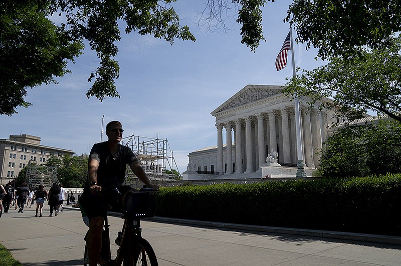 People pass by the U.S. Supreme Court in Washington earlier this month. In a ruling Wednesday, the court put limits on when police officers can enter a home without a warrant while pursuing someone suspected of a minor crime.
(The New York Times/Stefani Reynolds)