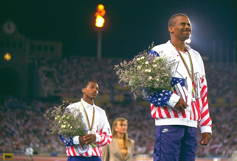U.S. triple jump Olympians Charles Simpkins of Aiken, S.C., left, silver medalist and gold medalist Mike Conley of Fayetteville, Ark., stand on the winners platform, Monday August 3, 1992, in Barcelona.(AP Photo/Eric Risberg)