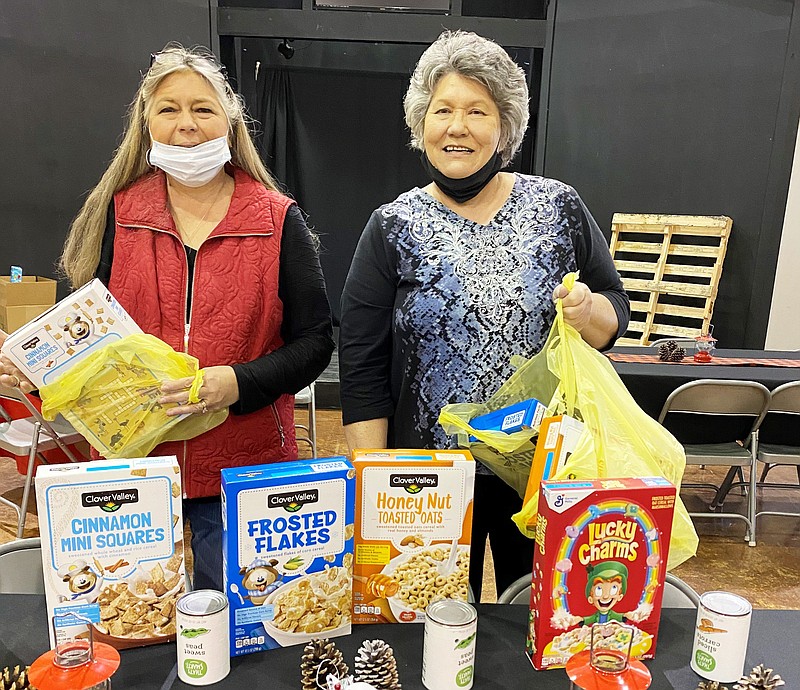 Debbie James (left) and Kaye Richardson sack donations from the Heart-N-Hands Extension Homemakers Club for the Transformation Project. 
(Special to The Commercial)