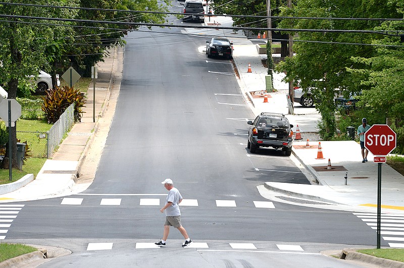 People walk Thursday near a new section of sidewalk along Church Avenue in Fayetteville. The city is in the middle of a $3 million project using bond money that voters approved in April 2019 to install new streetlights and sidewalks in the city’s downtown.
(NWA Democrat-Gazette/Andy Shupe)