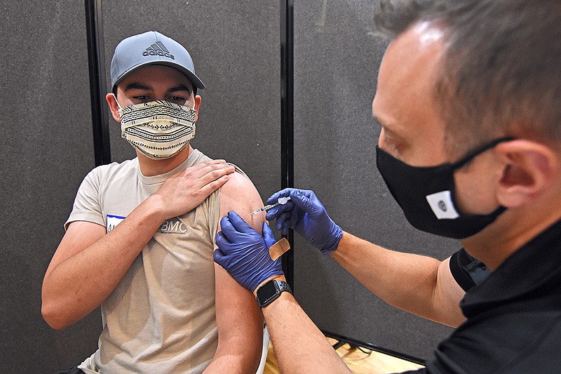 Alec DeSantiago of Little Rock gets his first dose of the Pfizer coronavirus vaccine from Nick Dziurkowski, a pharmacist for the Pharmacy at Wellington, Sunday, June 27, 2021, during the Community Health Fair at the Islamic Center of Little Rock. (Arkansas Democrat-Gazette/Staci Vandagriff)