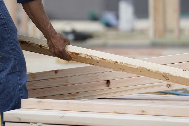 A workman arranges a beam on a frame at a home construction site in Madison County, Miss., this spring. Growth in U.S. manufacturing slowed slightly in June.
(AP/Rogelio V. Solis)