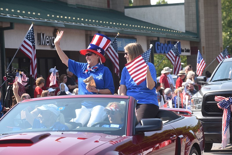 Janet Alton (left) and Corey Koster, with Village Bible Church, take part Saturday July 3 2021 in the annual Fourth of July Patriot Parade in Bella Vista.