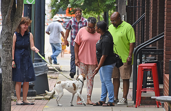 A group of people chat on the sidewalk along East 3rd Street on July 1, 2021 in downtown Little Rock..(Arkansas Democrat-Gazette/Staci Vandagriff)