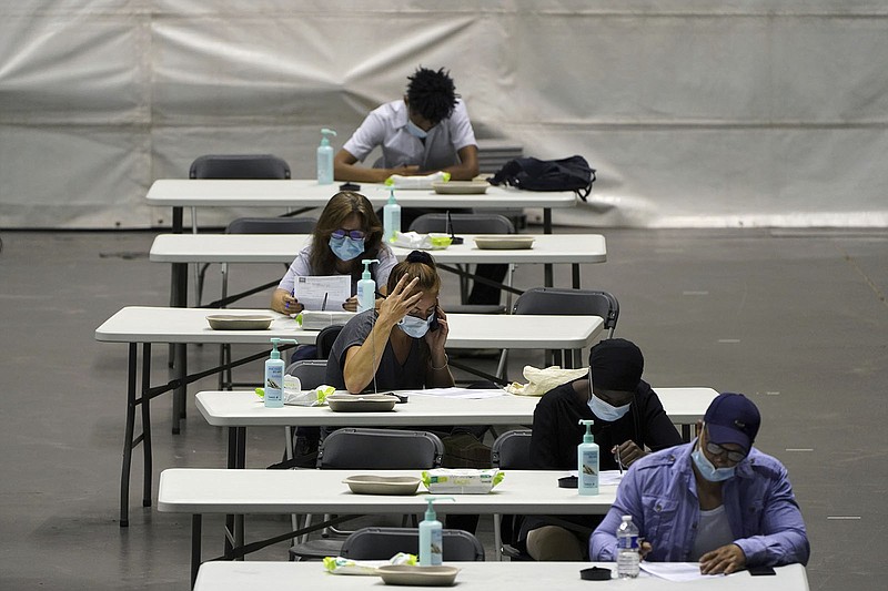 People fill out forms to get the Pfizer vaccine Wednesday at a vaccination center in Lyon in central France. Warnings of a fourth wave by Health Minister Olivier Veran have jolted more people into getting the shots.
(AP/Laurent Cipriani)