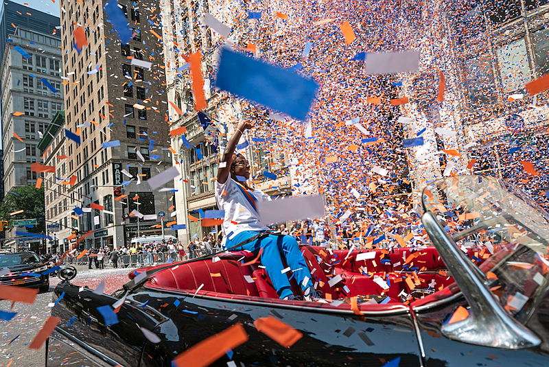 Grand marshal Sandra Lindsay, a health care worker who was the first person in the country to get a covid-19 vaccine shot, waves to spectators as she leads marchers through the Financial District as confetti falls during a parade honoring essential workers for their efforts in getting New York City through the covid-19 pandemic, Wednesday, July 7, 2021, in New York. (AP/John Minchillo)