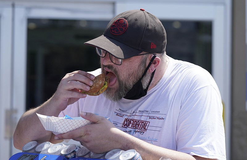 A shopper takes a bite outside a Sam’s Club in McKinney, Texas, in June as retailers begin again to offer free samples since the practice was halted during the pandemic.
(AP/LM Otero)