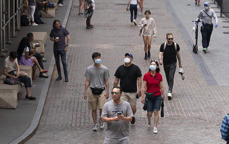 People walk on Wall Street near the New York Stock Exchange on Thursday. Stocks fell broadly early in the day as traders turned cautious after a streak of record highs for major U.S. indexes.
(AP/Mark Lennihan)