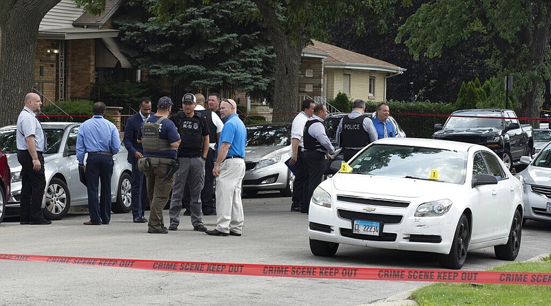 Officers with the Chicago Police Department work on a crime scene in a residential neighborhood on Wednesday, June 7, 2021. Three undercover law enforcement officers were shot and wounded Wednesday morning while driving onto an expressway on Chicago’s South Side, and detectives were questioning a “person of interest” about the shooting, police said. (Brian Rich/Chicago Sun-Times via AP)