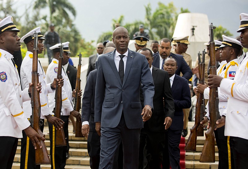 FILE - In this April 7, 2018, file photo, Haiti’s President Jovenel Moise, center, leaves the museum during a ceremony marking the 215th anniversary of revolutionary hero Toussaint Louverture’s death, at the National Pantheon museum in Port-au-Prince, Haiti. Moïse was assassinated after a group of unidentified people attacked his private residence, the country’s interim prime minister said in a statement Wednesday, July 7, 2021. (AP Photo/Dieu Nalio Chery, File)