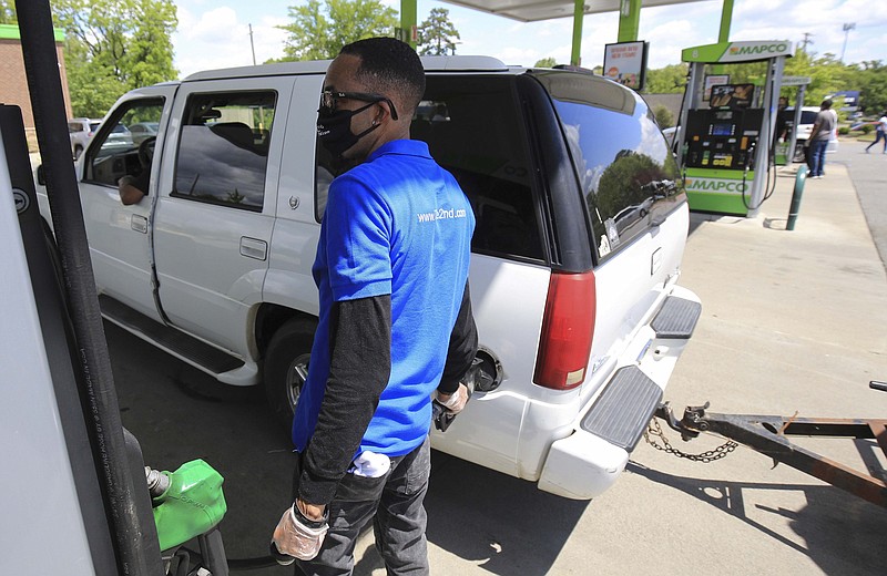 Timothy Lambert with Second Baptist Church puts gas in a car at the Mapco station at Kanis Road and Barrow Road in Little Rock in this April 29, 2020, file photo. The church gave away about $2,000 worth of gas, along with lunches, paid for in part with a grant to the church from the Arkansas Community Foundation. (Arkansas Democrat-Gazette/Staton Breidenthal)