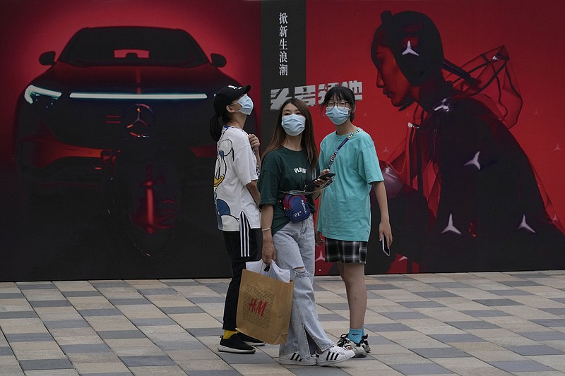 Shoppers pass advertisements for Mercedes Benz vehicles Thursday at a shopping mall in Beijing. China’s auto sales rose 27% in the first half of 2021 from a year earlier.
(AP/Ng Han Guan)