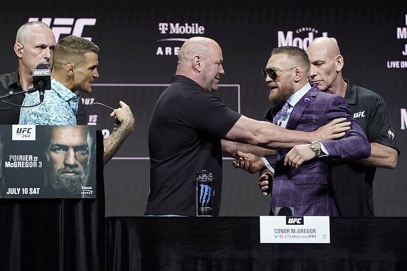 UFC President Dana White (center) holds Conor McGregor away from Dustin Poirier during Thursday’s news conference for today’s UFC 264 mixed martial arts bout in Las Vegas. McGregor and Poirier each have a victory in their first two fights against each other.
(AP/John Locher)