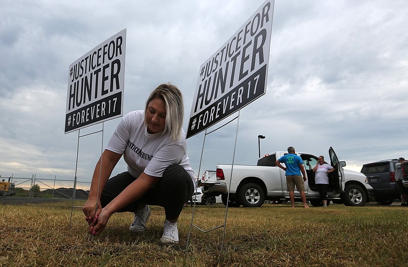 Stacy Travis of Beebe posts signs reading "Justice For Hunter #Forever17" on Thursday, July 1, 2021, in Lonoke. Travis was attending the nightly rally outside the Lonoke County sheriff's office protesting the June shooting death of 17-year-old Hunter Brittain. (Arkansas Democrat-Gazette/Thomas Metthe)