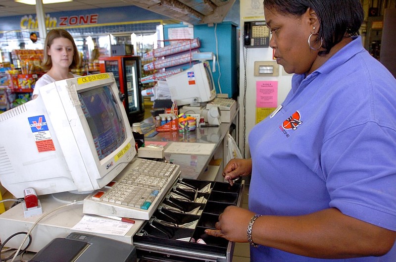 Ella Davis works the cash register behind the counter at the Lakewood Exxon in North Little Rock in this September 2005 file photo. (Arkansas Democrat-Gazette file photo)