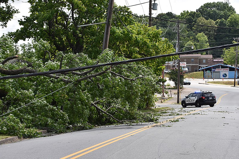 A Little Rock Police Department cruiser blocks off a section W. 29th Street where a tree and power line were blown over during Sunday morning’s storm in Little Rock. (Arkansas Democrat-Gazette/Staci Vandagriff)