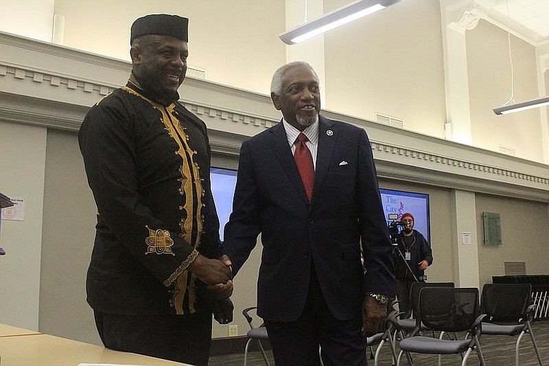 Artist Ibiyinka Alao shakes Fort Smith Mayor George McGill’s hand Tuesday, July 6, 2021, at a news conference at the Fort Smith Regional Chamber of Commerce.