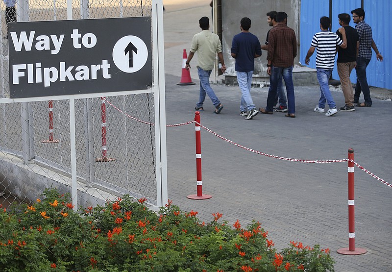 FILE -- People walk past a signage at the Flipkart headquarters in Bangalore, India, Wednesday, May 9, 2018. (AP Photo/Aijaz Rahi)