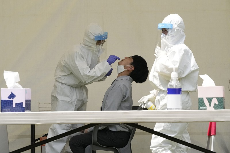 Medical workers conduct coronavirus testing Thursday at a makeshift site at the National Assembly in Seoul, South Korea. South Korea has added 1,600 more coronavirus cases, while a shortage of vaccines has left 70% of the population still waiting for a first shot.
(AP/Ahn Young-joon)