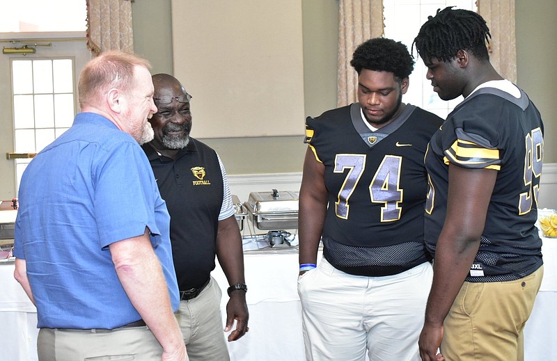 Watson Chapel School District Superintendent Andrew Curry (from left) meets high school football assistant coach Prestard Jordan and players Earnest Harris (74) and Lamar Jefferson (99) on Thursday before a Rotary Club of West Pine Bluff luncheon. 
(Pine Bluff Commercial/I.C. Murrell)