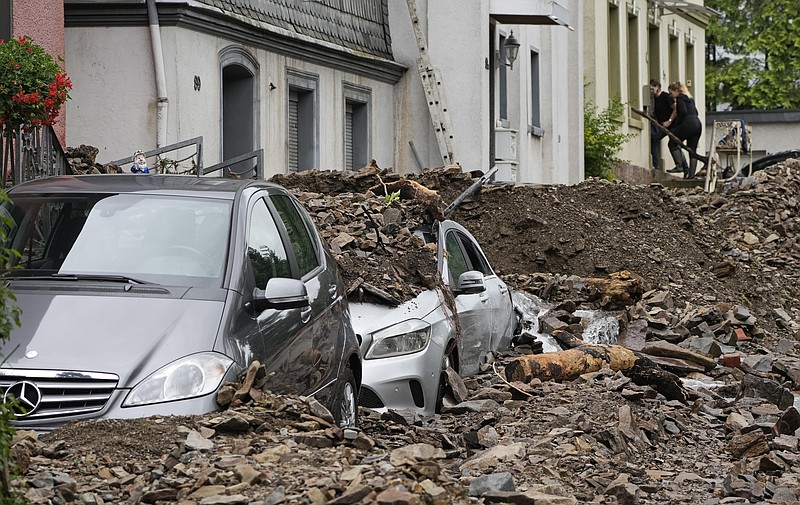 Cars are covered in Hagen, Germany, Thursday, July 15, 2021 with the debris brought by the flooding of the 'Nahma' river the night before.(AP/Martin Meissner)