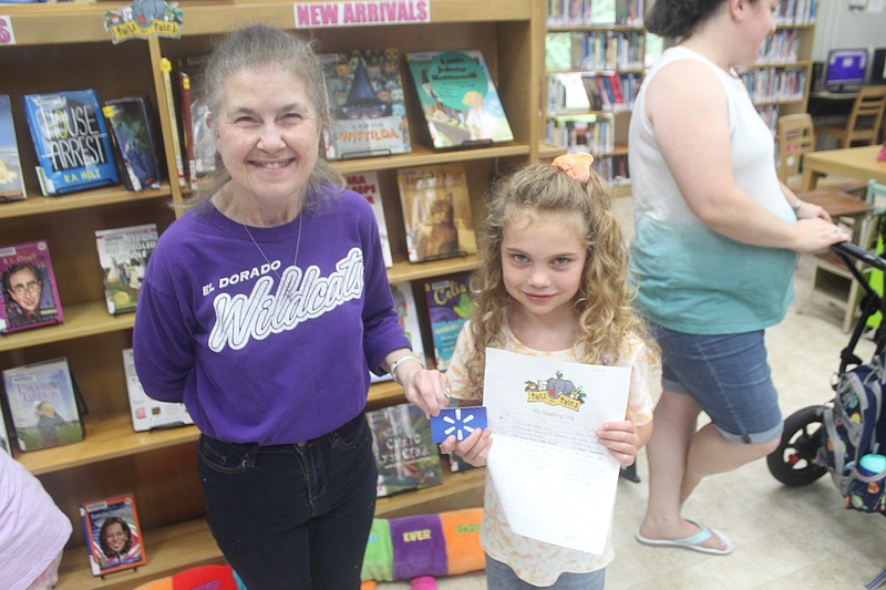 Librarian Karla Nelson leads the reading program and took time to pose for a picture with one of her many readers during the summer reading program party at Barton Library on Friday