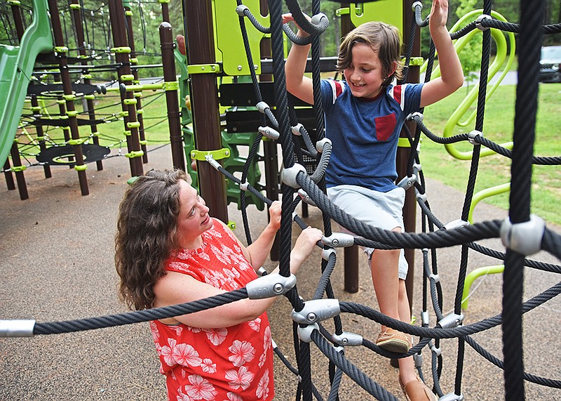Veronica McClane of Little Rock watches her son, Mac, 8, climb on playground equipment  Friday, July 17, 2021 at Reservoir Park in Little Rock..(Arkansas Democrat-Gazette/Staci Vandagriff)