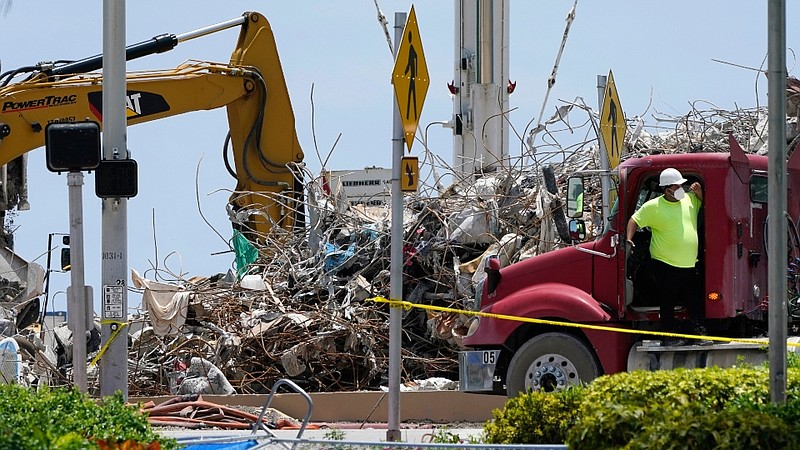 A worker waits to load his truck with debris from the rubble of the Champlain Towers South building, as removal and recovery work continues at the site of the partially collapsed condo building in Surfside, Fla. (AP Photo/Lynne Sladky)