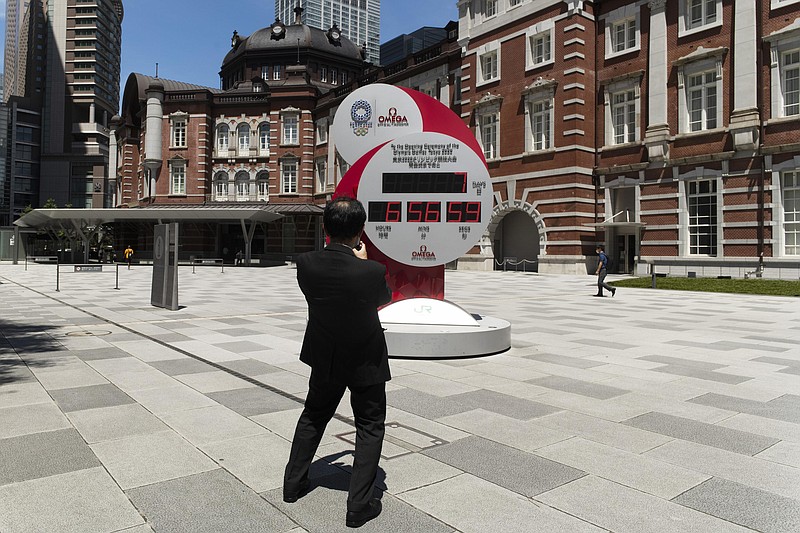 On Friday, a man takes a picture of a countdown clock that shows seven more days to go before the opening ceremony of the Tokyo Olympic Games in Tokyo. (AP Photo/Hiro Komae)