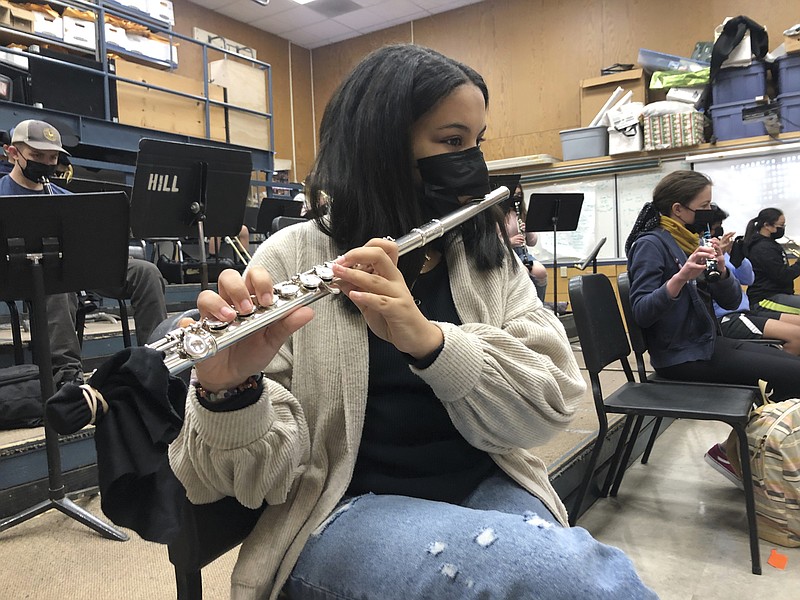 In this March 2, 2021 file photo, a student plays the flute while wearing a protective face mask during a music class at the Sinaloa Middle School in Novato, Calif.  With COVID-19 cases soaring nationwide, school districts across the U.S. are yet again confronting the realities of a polarized country and the lingering pandemic as they navigate mask requirements, vaccine rules and social distancing requirements for the fast-approaching new school year. (AP Photo/Haven Daily)