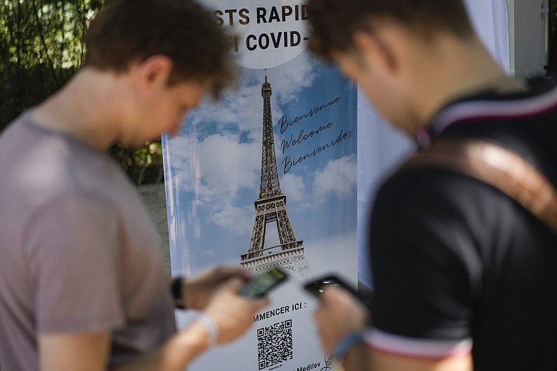 Visitors register for covid-19 tests Wednesday at the Eiffel Tower in Paris.
(AP/Daniel Cole)