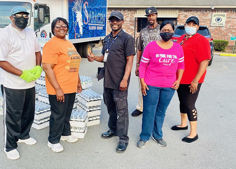 Zola Hudson (second from left) smiles Wednesday after a truck from Saracen Casino Resort delivered almost 5,400 12-ounce bottles of water to the city. Standing next to the mayor is Vinny Bullard (third from left), Saracen’s food and beverage steward. 
(Special to The Commercial)